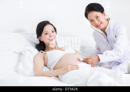 Arzt untersuchen schwangere Frau zu Hause Stockfoto