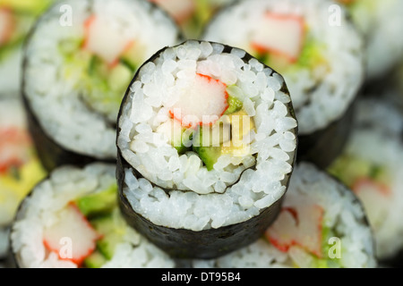 Extreme horizontale Nahaufnahme Foto einer Hand California roll Sushi mit Schwerpunkt im Zentrum Stockfoto