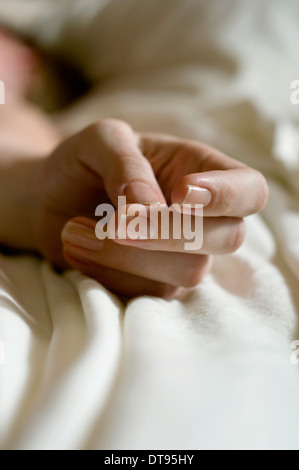 Eine Nahaufnahme von einem Womans Hand auf einem Bett Stockfoto