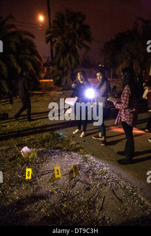 Hispanic regionale Besetzung Programm (ROP) Studenten Leuchten Taschenlampen auf "Hinweise" in ein Verbrechen-Szene Untersuchung Outdoor-Klasse. Stockfoto