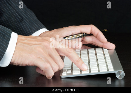 Nahaufnahme eines Geschäftsmannes drücken geben Sie auf der Computertastatur. Stockfoto