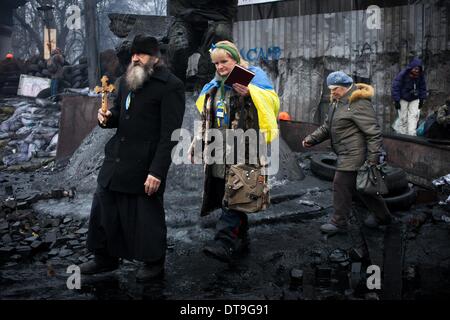 Kiew, Ukraine. 10. Februar 2014. Ein Priester betet zwischen Polizei und Demonstranten in der Szene der Anti-Regierungs-Proteste in der Nähe von Dynamo-Stadion am 11. Februar 2014 in Kiew, Ukraine. Gewaltsame Proteste in der Ukraine haben jenseits der Hauptstadt verbreitet, wie Präsident Viktor Yanukovych Krise mit drei wichtige Oppositionsführer Gespräche. Foto von Emeric Fohlen/NurPhoto Credit: Emeric Fohlen/NurPhoto/ZUMAPRESS.com/Alamy Live-Nachrichten Stockfoto