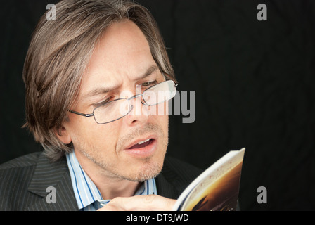 Nahaufnahme eines lässig Geschäftsmann mit Brille, ein Buch zu lesen. Stockfoto