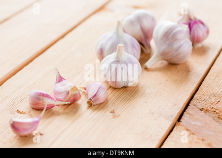 Gesunde Bio-Knoblauch Gemüse ganze und Nelken auf dem hölzernen Hintergrund Stockfoto