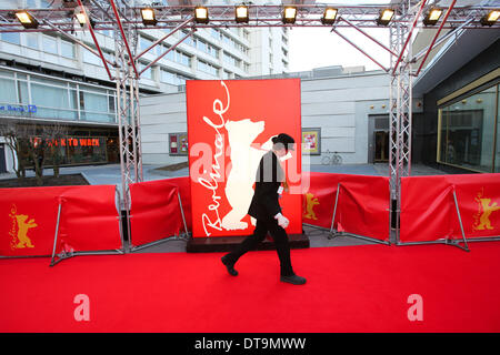 Berlin, Deutschland. 12. Februar 2014. Ein Mitarbeiter geht auf dem roten Teppich vor dem Zoo-Palast-Kino in Berlin, Deutschland, am 12. Februar 2014. Bekannt als "Berlinale Heimat", wurde der Berliner Zoo Palast Kino Berlinale Hauptschauplatz von 1957 bis 1999. Nach umfangreichen Sanierungsarbeiten seit Ende 2010 das Kino wurde am 27. November 2013 wieder eröffnet und wurde wieder ein wichtiger Standort für die 64. Internationalen Filmfestspiele Berlinale im Jahr 2014. © Zhang Fan/Xinhua/Alamy Live-Nachrichten Stockfoto