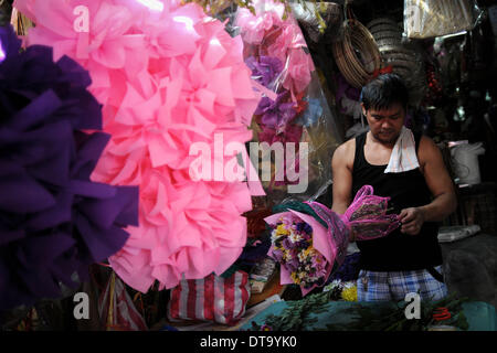 Manila, Philippinen. 13. Februar 2014. Eine Blume-Hersteller bereitet einen Blumenstrauß zum Verkauf einen Tag vor Valentinstag auf dem Dangwa Blumenmarkt in Manila, Philippinen, 13. Februar 2014 oben gesetzt werden. Viele Blumenhändler haben beginnt mit dem Verkauf von Blumen und Rosen aus Anlass des Valentins Day.Photo: Ezra Acayan/NurPhoto Credit: Ezra Acayan/NurPhoto/ZUMAPRESS.com/Alamy Live News Stockfoto