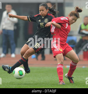 Chongqing, China. 13. Februar 2014. Xu Yanlu (R) von China wetteifert mit Karla Nieto von Mexiko während der internationalen Frauen Fußball-Turnier zwischen China und Mexiko in Chongqing, Südwest-China, 13. Februar 2014. China 3: 1 gewonnen. © Chen Cheng/Xinhua/Alamy Live-Nachrichten Stockfoto