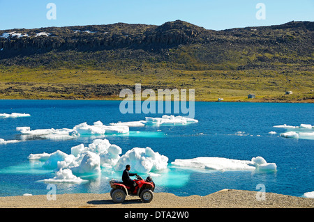 Mann des Inuit-Volkes Reiten ein Quad-Bike, ATM, parkte am Ufer der Beaufortsee, Nordpolarmeer, Victoria-Insel Stockfoto