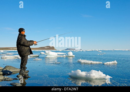 Mann von den Inuit Angeln am Ufer der Beaufortsee, Nordpolarmeer, Victoria-Insel, früher Holman Insel Stockfoto