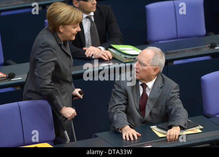 Berlin, Deutschland. 13. Februar 2014. Bundeskanzlerin Angela Merkel und Finanzminister Wolfgang Schaeuble reden im Deutschen Bundestag in Berlin, Deutschland, 13. Februar 2014. Foto: RAINER JENSEN/Dpa/Alamy Live-Nachrichten Stockfoto