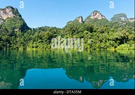 Bewaldeten Kalkstein Karstgebirge mit Dschungelvegetation spiegelt sich im Wasser, Rachabrapha Reservoir, Chiao Lan See Stockfoto