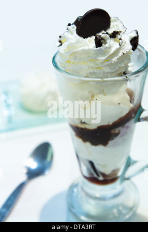 Vanilleeis mit Schokolade Sirup und Kirsche garniert Stockfoto