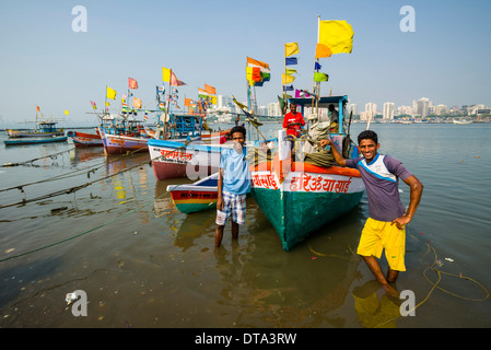 Zwei Fischer und einige Fischerboote vor der Skyline des Vororts Churchgate gesehen in Back Bay, Mumbai Stockfoto