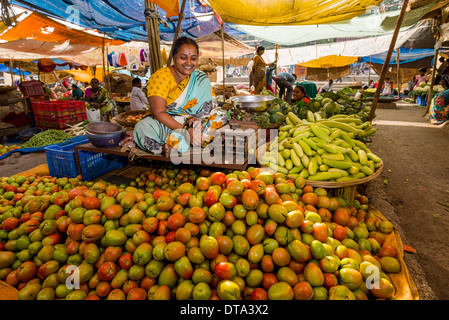 Eine Frau verkauft Tomaten und Gurken auf dem Wochenmarkt Gemüse Nasik, Maharashtra, Indien Stockfoto