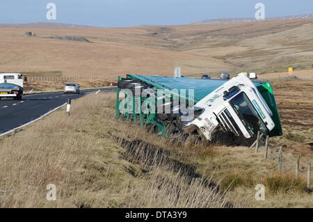 Woodhead Pass, UK. 13. Februar 2014. Ein umgestürzter LKW auf der A628 Woodhead Pass zwischen Manchester und Barnsley, verursacht durch eine sev Stockfoto