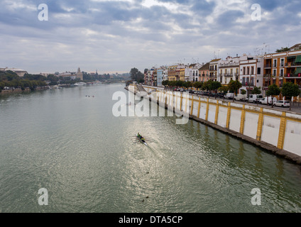 SEVILLA SPANIEN RUDERER UND BOOTE AUF DEM FLUSS GUADALQUIVIR IN DEN FRÜHEN MORGENSTUNDEN Stockfoto