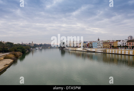 Sevilla Spanien den GUADALQUIVIR UND BEIDE BANKEN GEGEN EINE BRIDGEguadalquivir Stockfoto