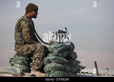 Parwan, Afghanistan. 13. Februar 2014. Ein Afghan National Army Soldat wacht von einem Maschinengewehr außerhalb der Bagram Detention Center in Parwan Provinz, Nord-Afghanistan, am 13. Februar 2014. Die Vereinigten Staaten Streitkräfte-Afghanistan (USFOR-A) am Donnerstag verurteilt die Freisetzung von Taliban Insassen von der afghanischen Regierung aus der ehemaligen Haftanstalt der US-geführten Bagram früher am Tag. Bildnachweis: Ahmad Massoud/Xinhua/Alamy Live-Nachrichten Stockfoto