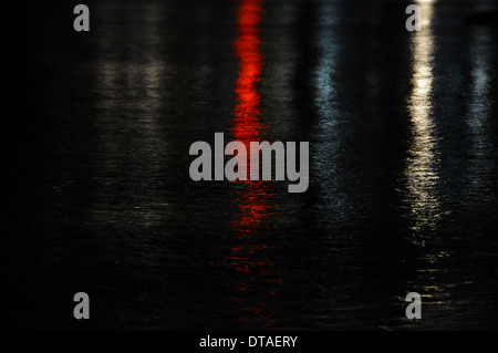 Bunte Stadt-Lichter reflektiert auf dem dunklen Meerwasser. Nacht abstrakten Hintergrund. Stockfoto