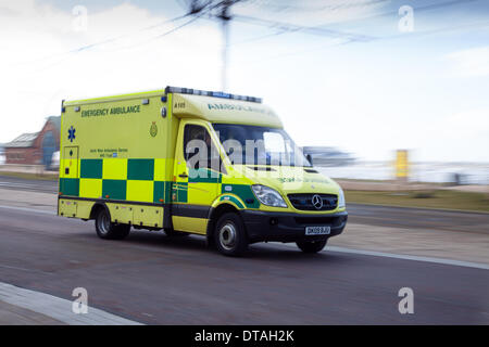 999 NHS North West Rettungswagen Blackpool, Großbritannien, 13. Feb 2014. Einen großen Einsatz der Polizei und der Rettungsdienste, medizinische, Zeichen, Gesundheit, Sanitäter, Gesundheitswesen, Transport, Verkehr, Krankenhaus, Krankenwagen, die an der Strandpromenade zum Turm Esplanade reagiert und patrouillieren Promenade wie Hochwasser und Sturm Winde weiter The Fylde Coast in Lancashire zu zerschlagen. Chief Brand der Regierung und Rettung Berater Peter Holland sagte, dass 70% der Feuerwehren und Rettungsdienste in England und Wales waren nun in der Flut Hilfsmaßnahmen beteiligt. Stockfoto