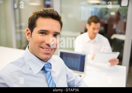 Porträt von lächelnd Geschäftsmann im Büro, auf der Kamera Suche Stockfoto