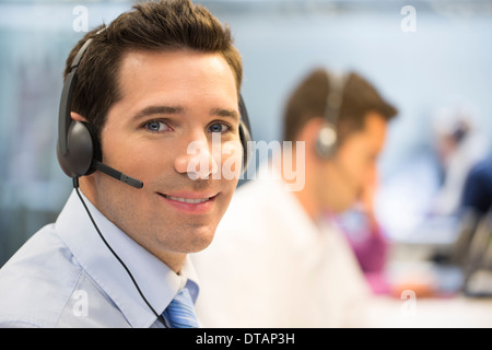 Porträt des Betreibers im Büro am Telefon mit Kopfhörer, Kamera suchen Stockfoto