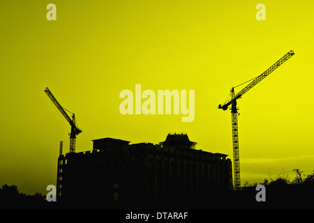 Industrielle Baukräne und Gebäude-Silhouetten Stockfoto
