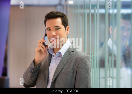 Porträt der Geschäftsmann auf Smartphone im Büro, auf der Kamera Suche Stockfoto