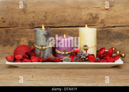 Drei, die Feng Shui in einer Petrischale mit Potpourri vor dem Hintergrund der alten Kerzen brennen verwitterte Holz Stockfoto