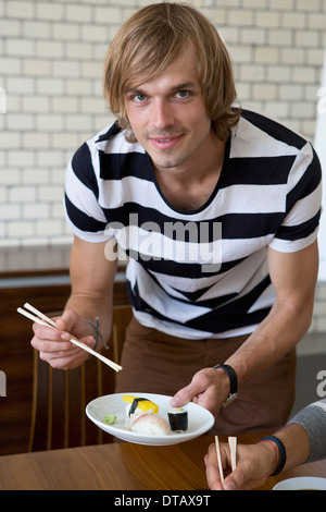 Mann mit Sushi und Stäbchen, Porträt Stockfoto