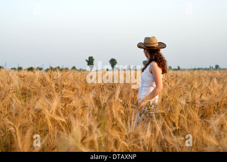 Mädchen im Weizenfeld im weißen Kleid und Stetson Hut. Selektiven Fokus. Stockfoto