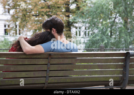 Junges Paar sitzt auf der Parkbank, Rückansicht Stockfoto