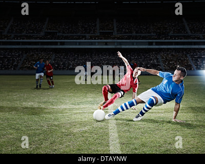 Fußball-Spieler kicken für Ball auf Feld Stockfoto