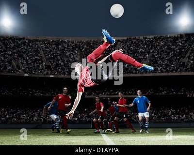 Fußball-Spieler treten Ball auf Feld Stockfoto