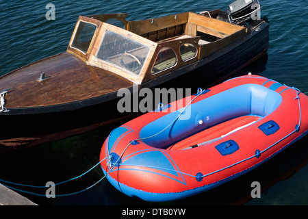 Ein Retro-Motorboot vertäut neben einem neuen Schlauchboot Stockfoto