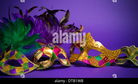 Festliche Gruppierung von Karneval, Venedig oder Karneval Masken auf lila Hintergrund Stockfoto