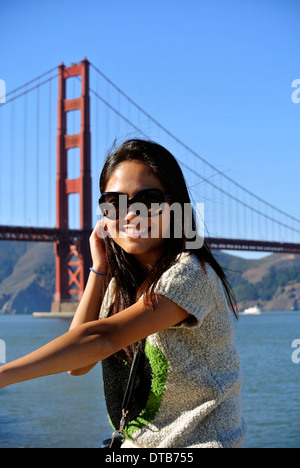 Ziemlich chinesischen Mädchen posiert für Fotografen mit Handy vor der Golden Gate Bridge Stockfoto