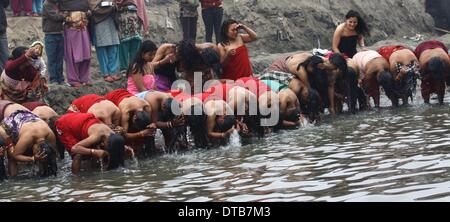 (140214)--KATHMANDU, 14. Februar 2014. (Xinhua)--nepalesischen Hindu Frauen Anhänger nehmen Heilige Dips am Fluss Hanumante während der letzte Tag des einmonatigen Madhav Narayan Festivals in Bhaktapur, Nepal, 14. Februar 2014. Während der einmonatigen Festival nepalesische Hindu-Frauen ein Fasten und beten zu Göttin Swasthani für Langlebigkeit ihrer Ehemänner und Familie Wohlstand während unverheiratete Frauen beten zu treffen und einen guten Mann zu heiraten. (Xinhua/Sunil Sharma) Stockfoto