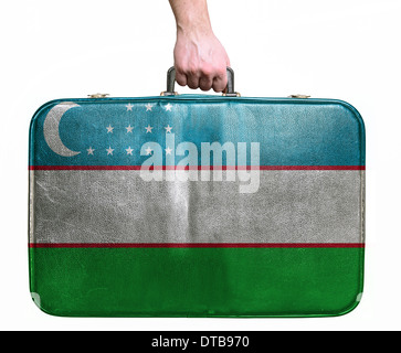 Touristischen Hand mit Vintage-Leder Reisetasche mit Flagge der Republik Usbekistan Stockfoto