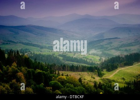 Schönen Himmel und Wald hoch oben in den Karpaten. Mit Blick auf Dorf nach Regen mit Sonnenstrahlen. Stockfoto