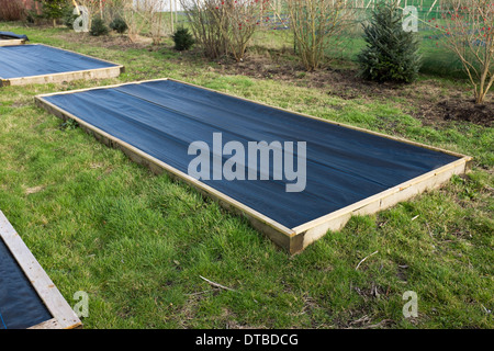 Hochbeeten im Winter mit Plastikplanen abgedeckt. Stockfoto