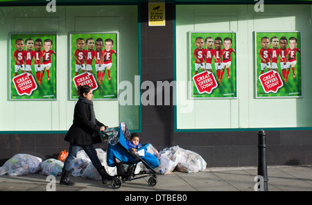 Eine Frau, die einen Kinderwagen schieben geht vorbei an einem Zweig der Paddy Power Buchmacher in Hackney, London, am 8. Januar 2014. Stockfoto