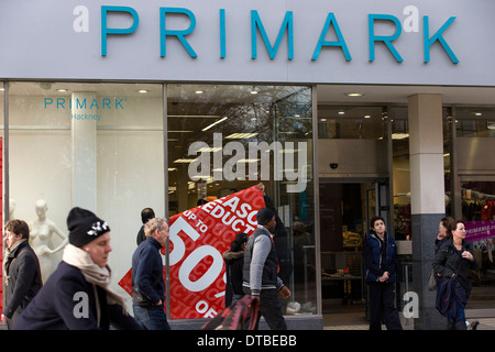 Vereinigtes Königreich, London: Shop-ArbeiterInnen anpassen "saisonalen Ermäßigungen bis zu 50 % Rabatt" Zeichen in einem Primark-Fenster in Hackney, London. Stockfoto