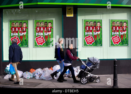 Eine Frau, die einen Kinderwagen schieben geht vorbei an einem Zweig der Paddy Power Buchmacher in Hackney, London, am 8. Januar 2014. Stockfoto