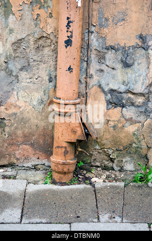 Regenwasser-Entwässerung Rinne Fallrohr an alten städtischen Hauswand Stockfoto