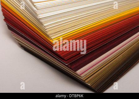 Farbiges Papier-Stapel in warmen Tönen Stockfoto