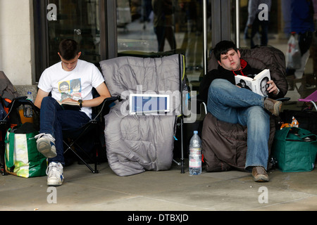 Apple-Fans lesen Sie Steve Jobs Biografie, wenn sie die Warteschlange drausen Apple speichern in Covent Garden zentrale London, England 20. September 2012. Apple hat heute eine größere, leichtere und schnellere iPhone, die bereit ist, das am schnellsten verkaufte Technik-Gadget Geschichte--werden auch zunehmender Konkurrenz im Smartphone-Markt $ 219,1 Milliarden. Apple am Mittwoch ergab, dass das neue iPhone 5 in den Läden in den USA und Großbritannien Morgen 21 September sein wird. Stockfoto