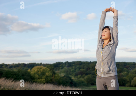 Junge weibliche Läufer Strecken Arme Stockfoto