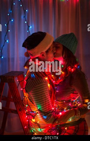 Junges Paar verpackt in Lichterketten zu Weihnachten Stockfoto