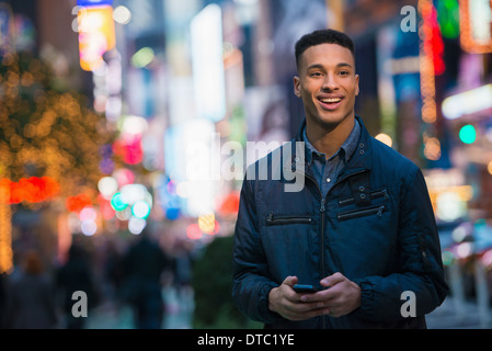 Junge männliche Touristen an viel befahrenen Straße, New York City, USA Stockfoto